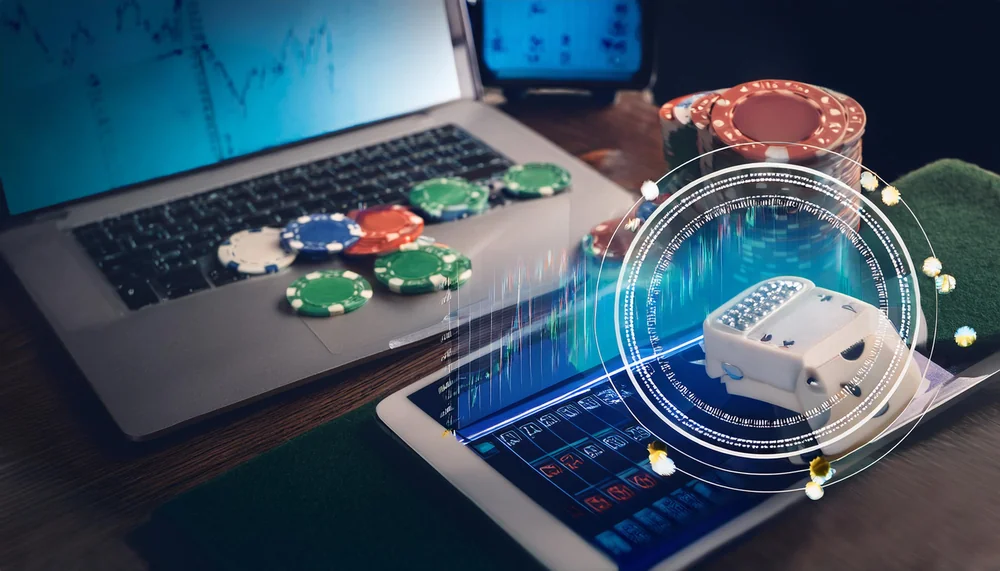 Laptop and tablet with trading charts and dice hologram on a dark desk